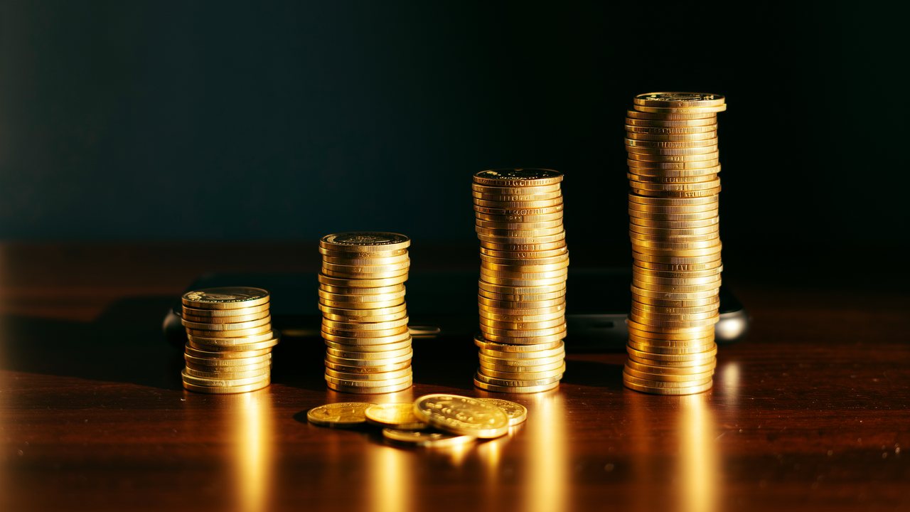 Tres pilas de monedas de oro de altura creciente sobre un escritorio: cuánto paga realmente cada casino online